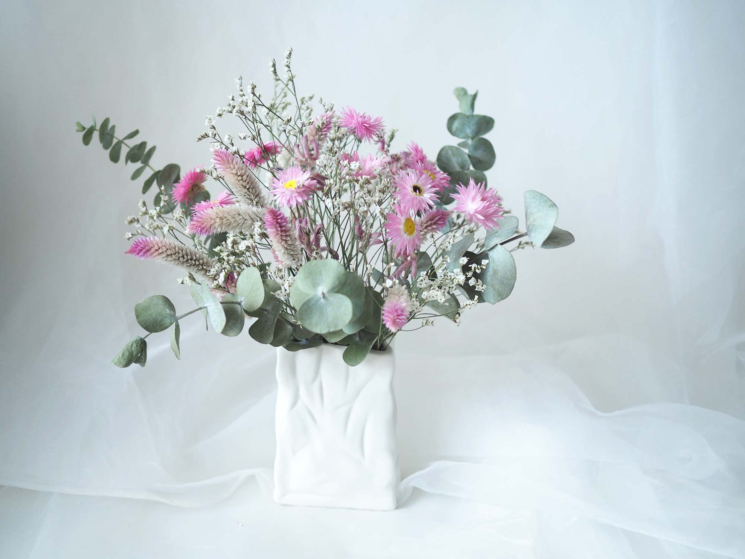 SYLVIE – purple, pink, white and green dried flowers in a white ceramic bag vase